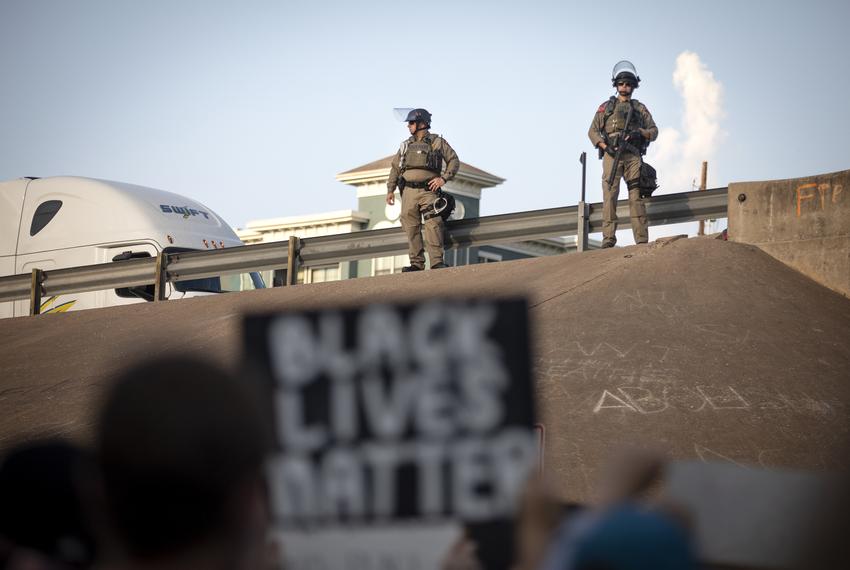 State troopers stand near an overpass on Interstate 35 to prevent protesters from blocking traffic during a rally at Austin police headquarters. 

